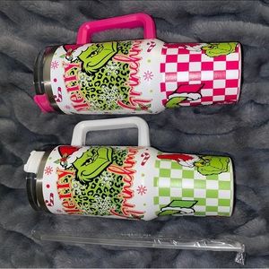1 pink and 1 green grinch tumbler.